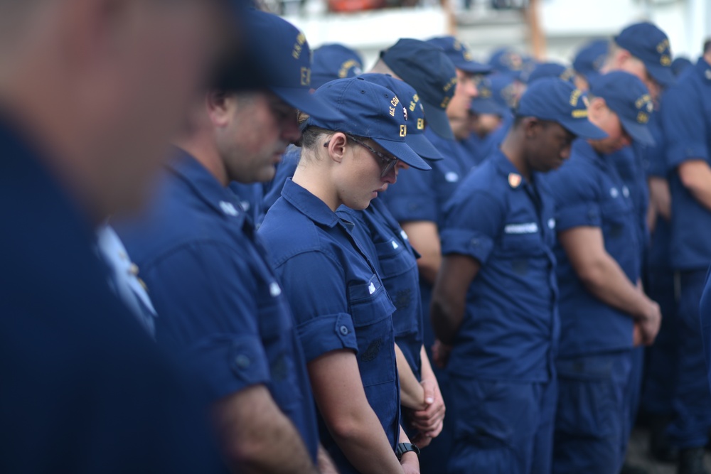 Coast Guard members aboard the U.S. Coast Guard Tall Ship Eagle take a moment in prayer