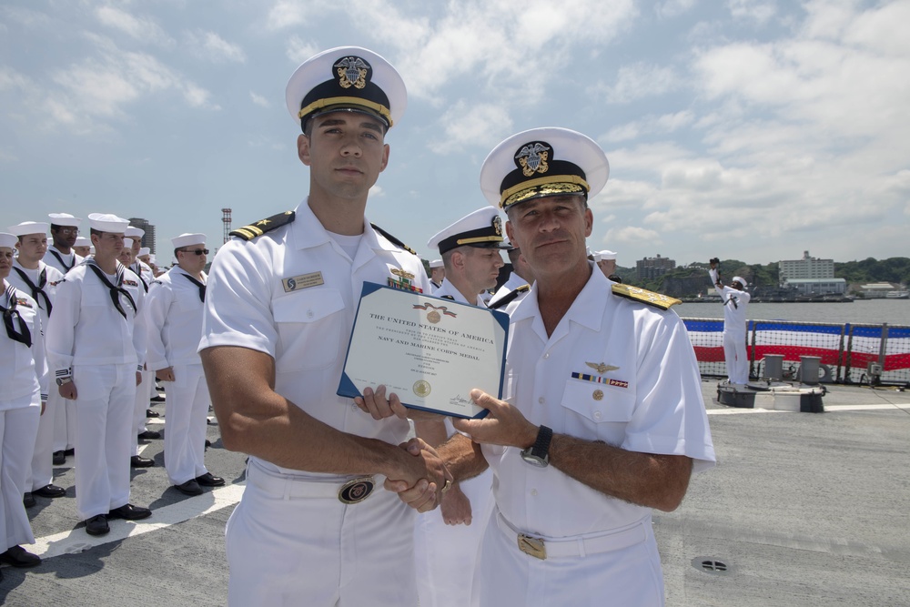 Admiral John Aquilino, Commander, Pacific FLeet, awards a Sailor during an awards ceremony on USS John S. McCain (DDG 56)