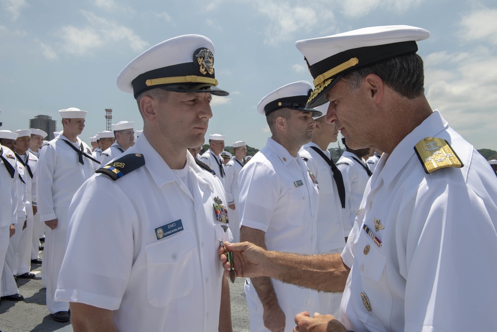 Admiral John Aquilino, Commander, Pacific FLeet, awards a Sailor during an awards ceremony on USS John S. McCain (DDG 56)