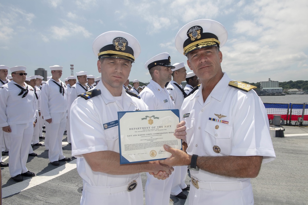 Admiral John Aquilino, Commander, Pacific FLeet, awards a Sailor during an awards ceremony on USS John S. McCain (DDG 56)