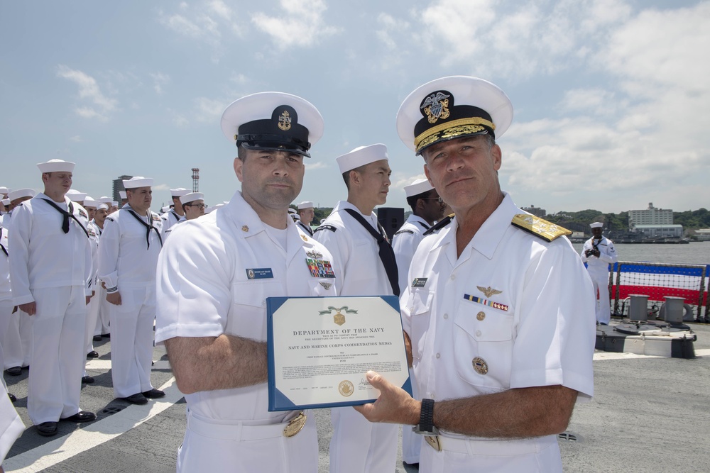 Admiral John Aquilino, Commander, Pacific FLeet, awards a Sailor during an awards ceremony on USS John S. McCain (DDG 56)