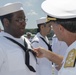 Admiral John Aquilino, Commander, Pacific FLeet, awards a Sailor during an awards ceremony on USS John S. McCain (DDG 56)