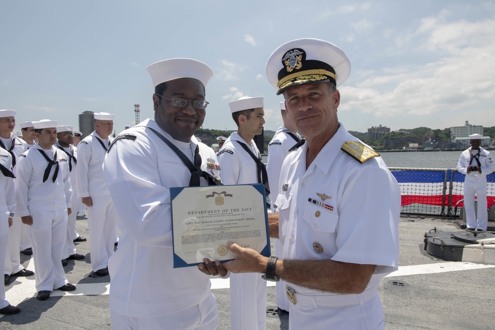 Admiral John Aquilino, Commander, Pacific FLeet, awards a Sailor during an awards ceremony on USS John S. McCain (DDG 56)