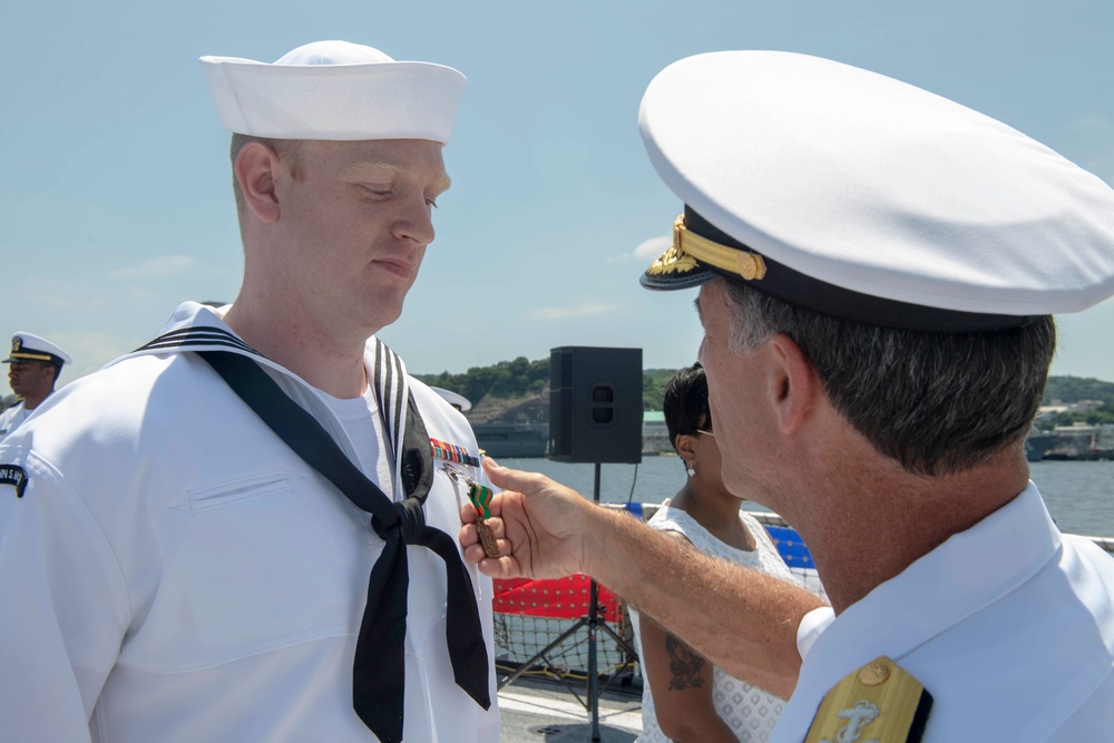 Admiral John Aquilino, Commander, Pacific FLeet, awards a Sailor during an awards ceremony on USS John S. McCain (DDG 56)