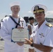 Admiral John Aquilino awards a Sailor during an awards ceremony on USS John S. McCain