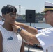 Admiral John Aquilino presents an award to the Ombudsman of USS John S. McCain (DDG 56) during an awards ceremony