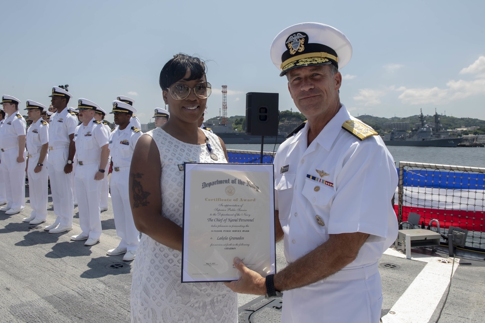 Admiral John Aquilino presents an award during a cermony onboard USS John S. McCain