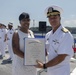 Admiral John Aquilino presents an award during a cermony onboard USS John S. McCain