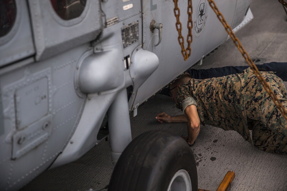 U.S. Marines and Sailors conduct FOD walk aboard the USS Bataan