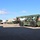 Fort McCoy supports USTRANSCOM's TMS prototype operations A military-painted olive drab Kalmar reach stacker is positioned in a large paved yard surrounded by intermodal shipping containers of various colors. The heavy equipment appears to be at a military logistics or container handling facility, likely used for loading and moving ISO containers. A flatbed trailer is visible in the background alongside multiple stacked containers.