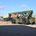 Fort McCoy supports USTRANSCOM's TMS prototype operations A military olive-green Kalmar reach stacker is parked on a concrete apron at what appears to be a military logistics or port facility. The heavy equipment vehicle is designed for lifting and moving intermodal shipping containers, several of which are visible in the background. The machine is unoccupied and appears to be in new or well-maintained condition.