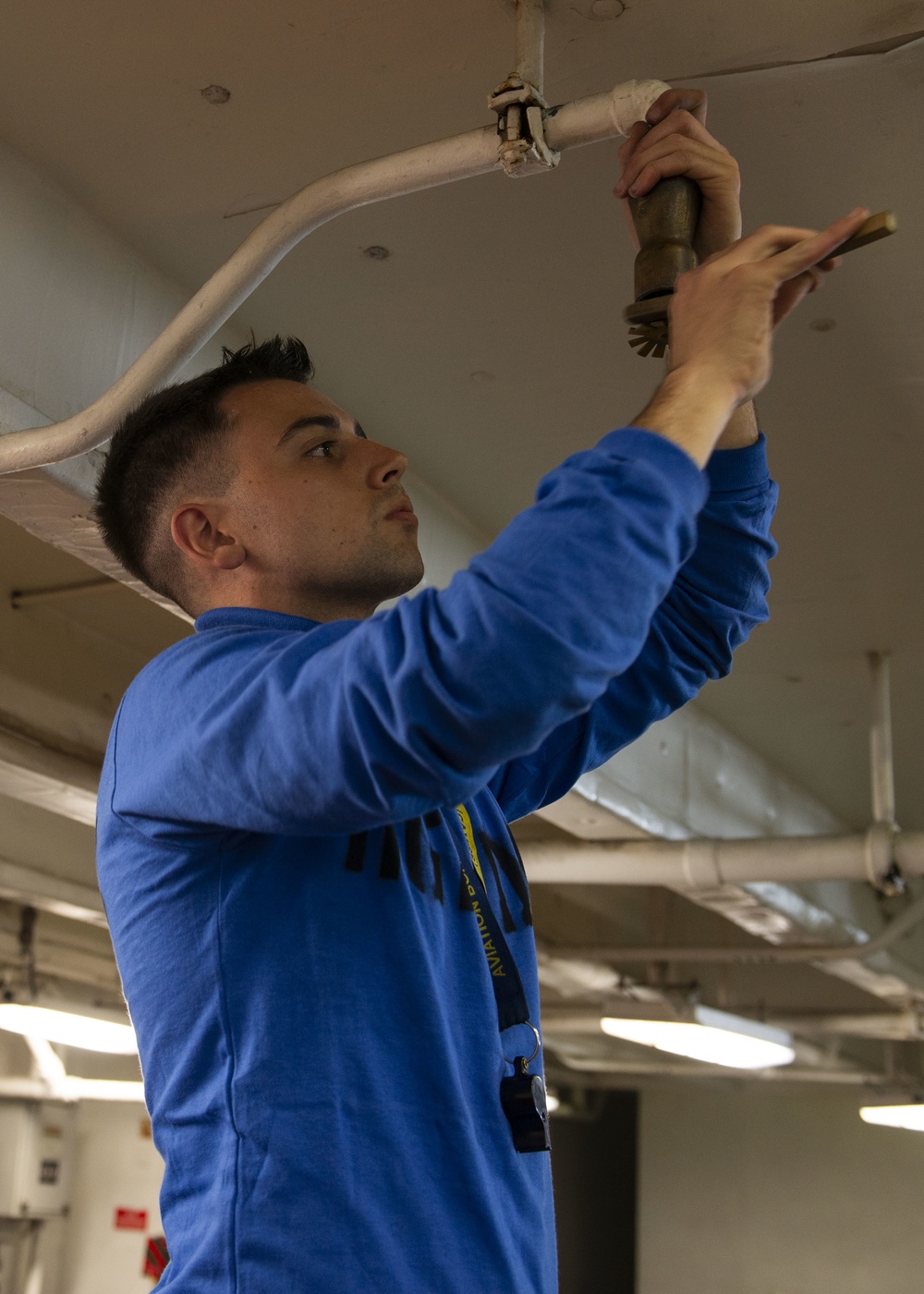 Sailor Cleans AFFF Sprinkler