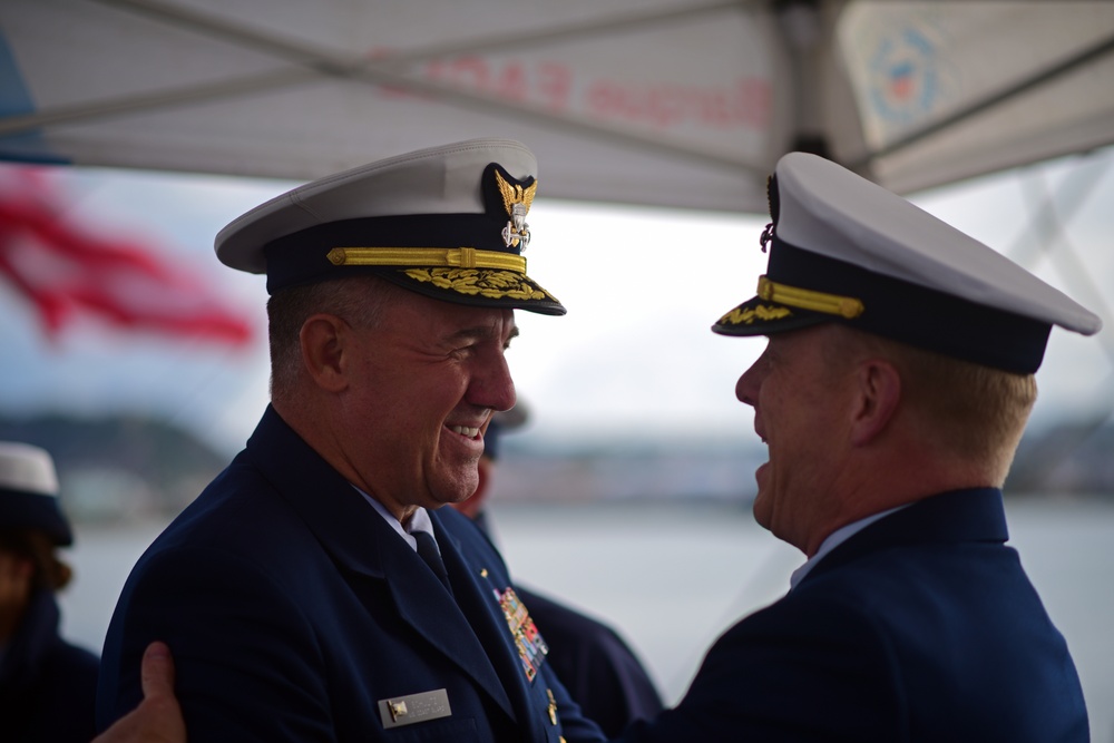 Commandant Karl Schultz is greeted by Capt. Matthew Meilstrup aboard the U.S. Coast Guard Tall Ship Eagle before a Navy ship naming ceremony