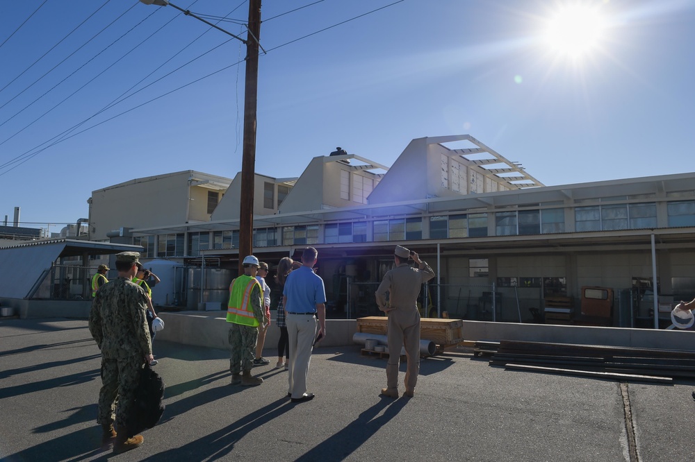 U.S. Sailors and civilians view damaged buildings