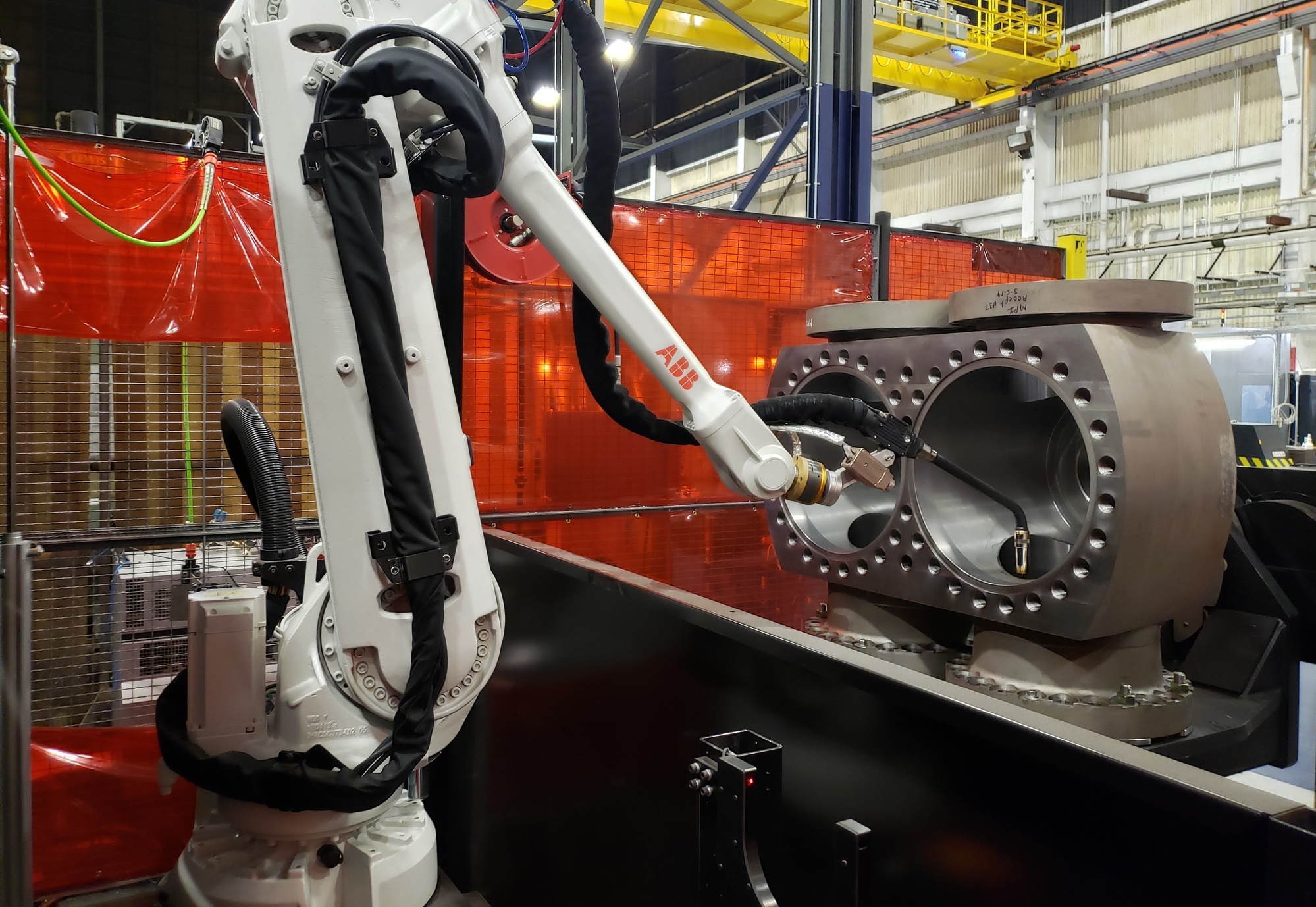 Robotic welding cell holding a production component in a manufacturing facility