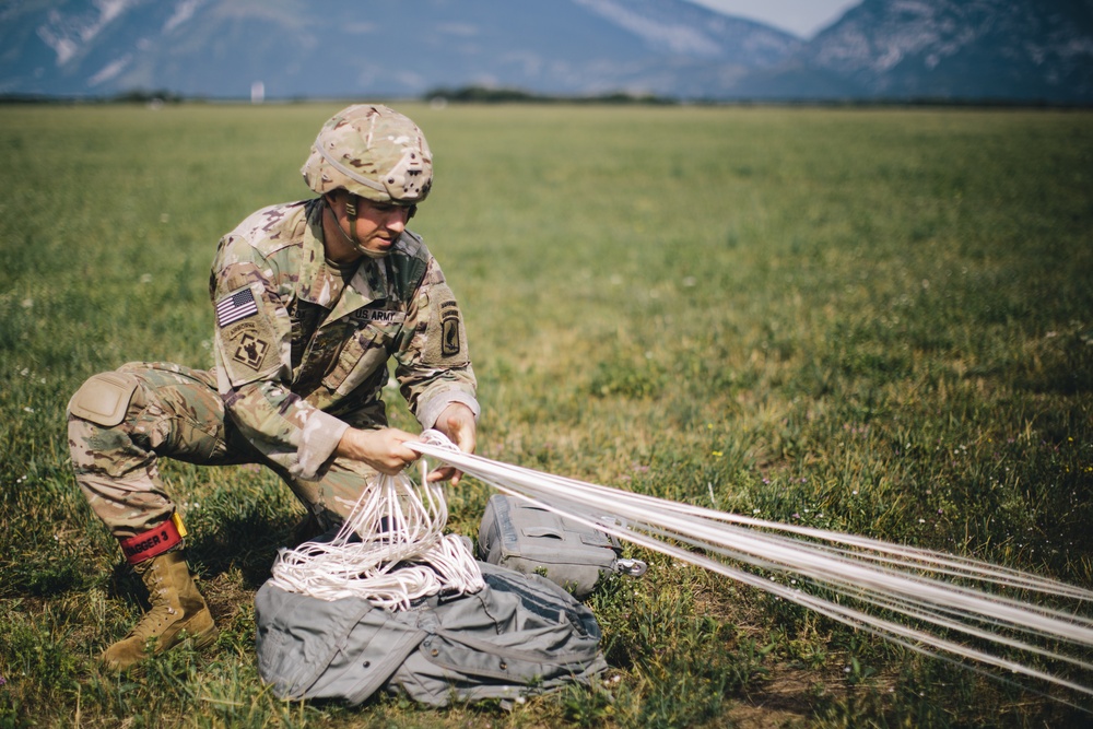 U.S. Army paratrooper prepares equipment for departure after airborne operation