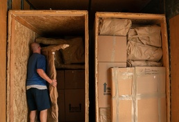 Movers pack personal property into crates