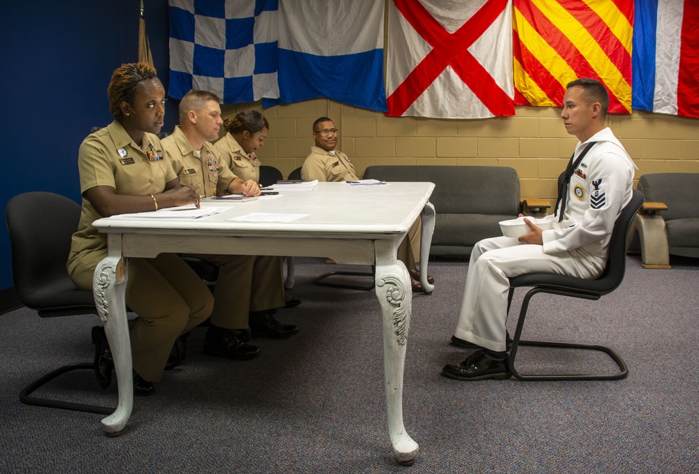 Sailors stand Sailor of the Quarter board at Navy Recruiting District Philadelphia.