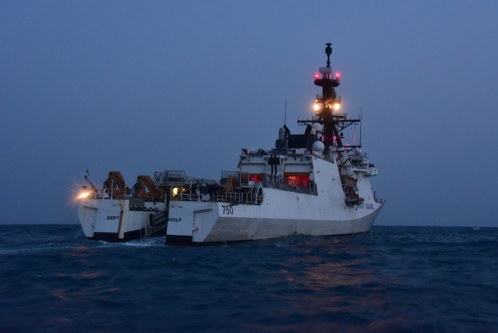 CGC Bertholf prepares to recover small boat as dusk falls in the East China Sea