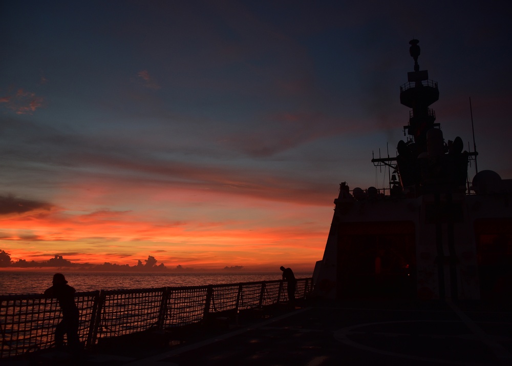 Bertholf crewmembers contemplate spectacular sunset at sea