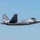Red Flag 19-3 take offs A U.S. Air Force F-22 Raptor stealth fighter jet is captured in level flight against a clear blue sky. The aircraft displays tail code 'FF' and a partial serial number '1061', indicating assignment to the 1st Fighter Wing based at Joint Base Langley-Eustis, Virginia. The image is a sharp, side-profile photograph likely taken at an airshow or during a training flight.