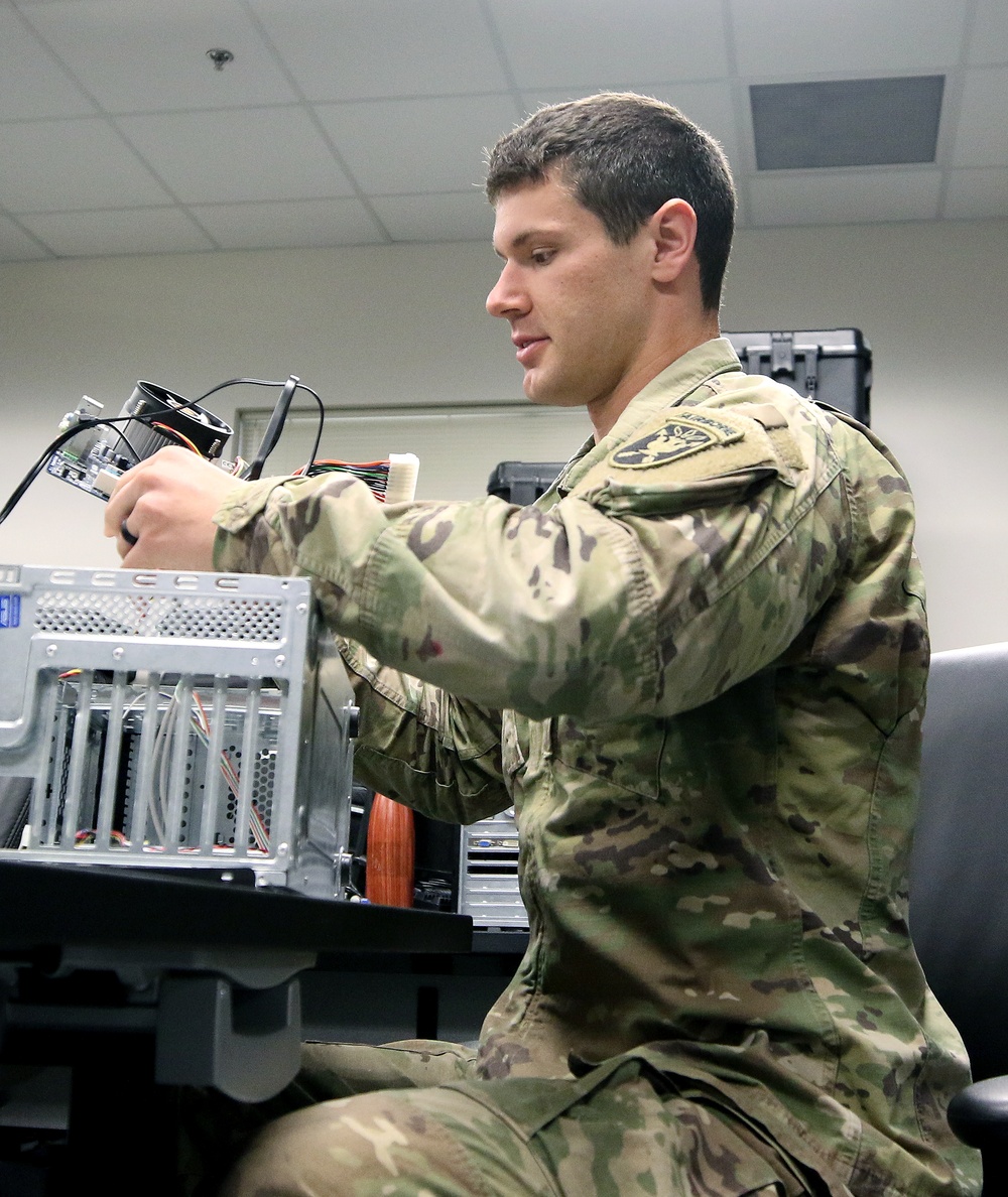 Student removes internal components of a personal computer during training at Fort Bragg, North Carolina