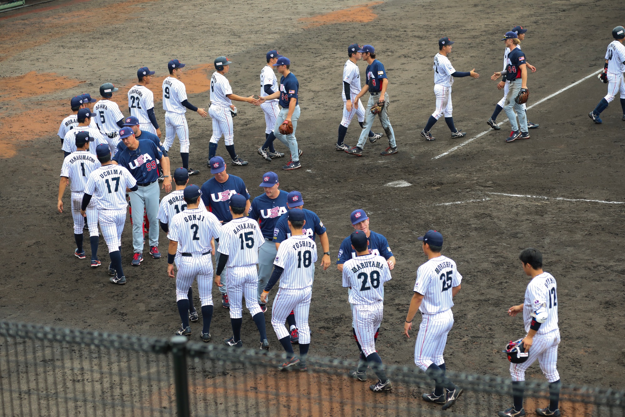 The USA and Japan collegiate baseball teams shake hands after a 2019 championship series game in Iwakuni City, Japan. Photo by Cpl. Stephen Campbell, U.S. Marine Corps, via DVIDS (public domain).