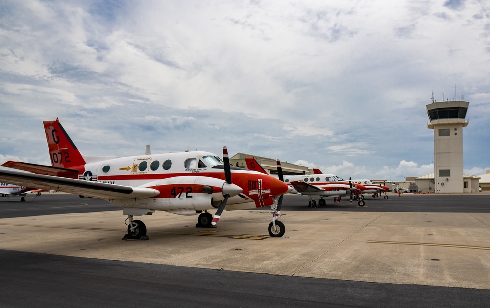 A line of T-44C Pegasus aircraft parked on the flightline aboard NAS Corpus Christi