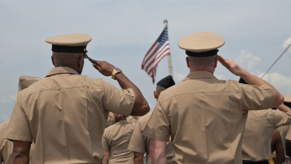 Saluting the National Ensign during a commissioning ceremony