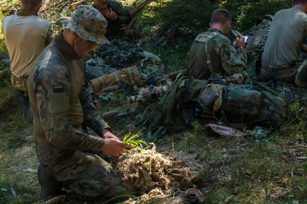 A Polish soldier prepares his camouflage for the stalking event during the European Best Sniper Competition.