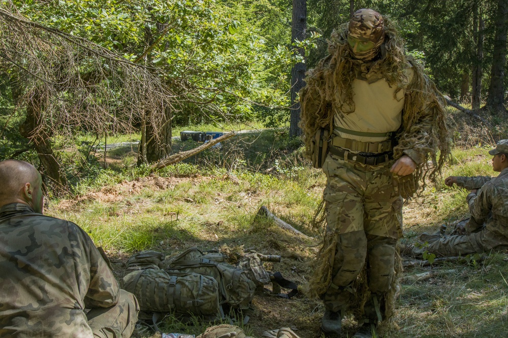 Two Polish soldiers engage in conversation before the stalking event during the European Best Sniper Competion, Grafenwoehr, Germany, July 23, 2019.