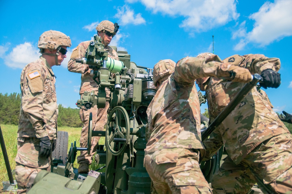 Student cannoneer team loads M777 A2 Howitzer