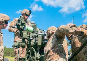 Student cannoneer team loads M777 A2 Howitzer
