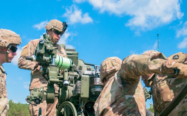 Student cannoneer team loads M777 A2 Howitzer