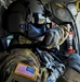 UH-60 Crew Chief adjusts helmet prior to lift-off