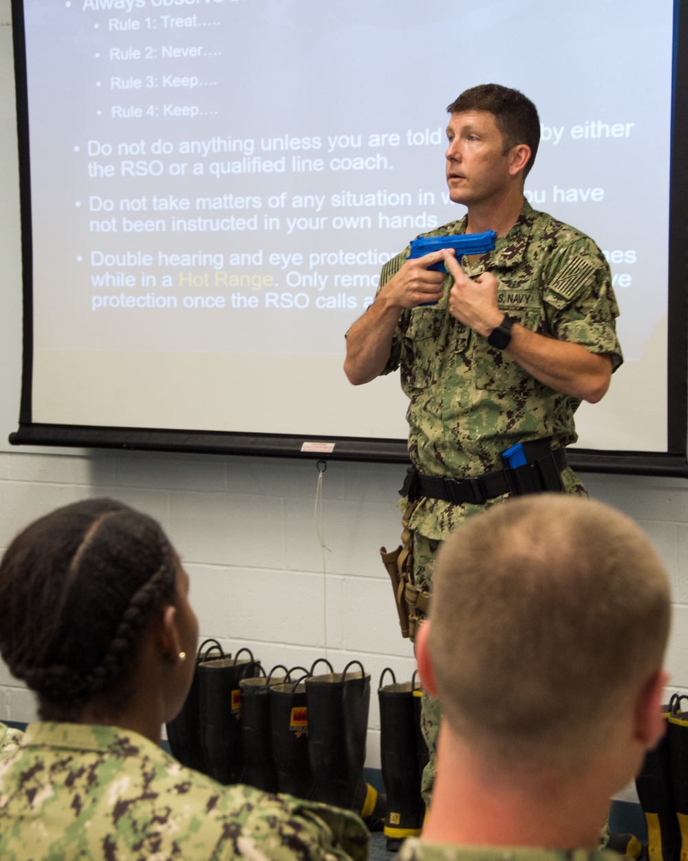 Aviation Ordnance Master Chief William Sullivan, the small arms trainer here at Officer Training Command, demonstrates safe weapons handling procedures to Officer Candidate School (OCS) class 15-19 candidates on July 30, 2019.