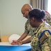 Electronics Technician Chief Jean F. Micourt trains Aviation Ordnanceman Chief LaChanda E. Parker how to properly conduct room, locker and personnel inspection (RLP) at Officer Candidate School (OCS) .