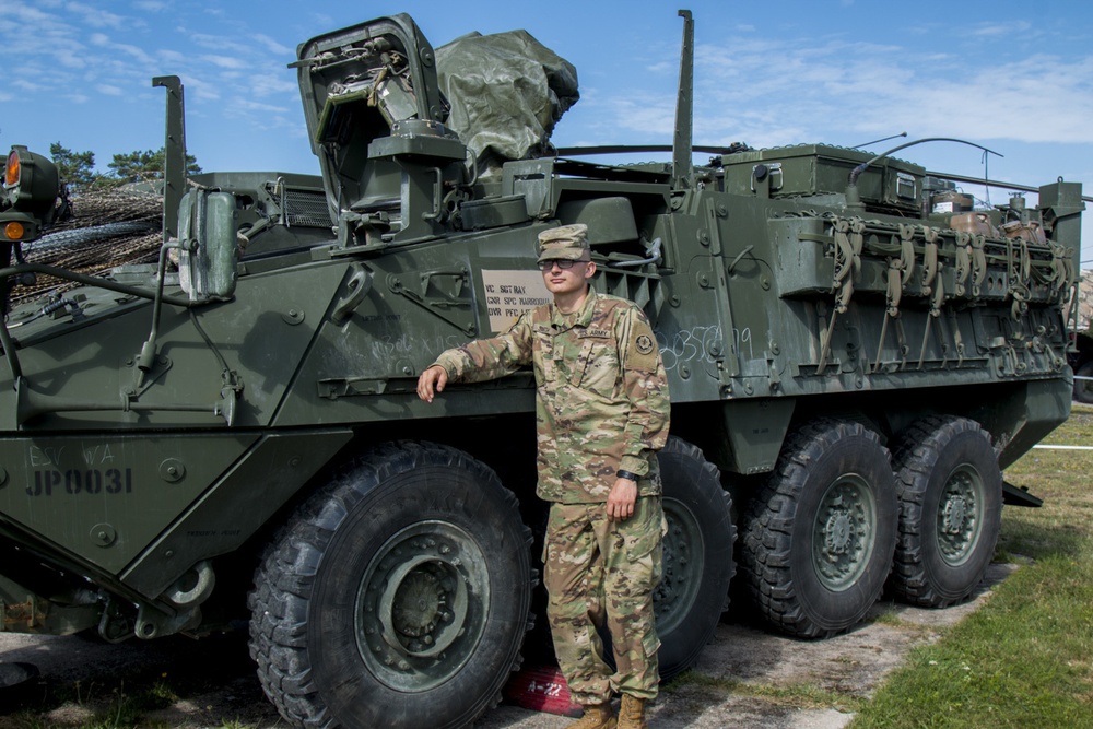 Pfc. Matthew Smith, assigned to 2CR, 7th ATC, stands in front of a stryker vehicle.