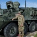 Pfc. Matthew Smith, assigned to 2CR, 7th ATC, stands in front of a stryker vehicle.