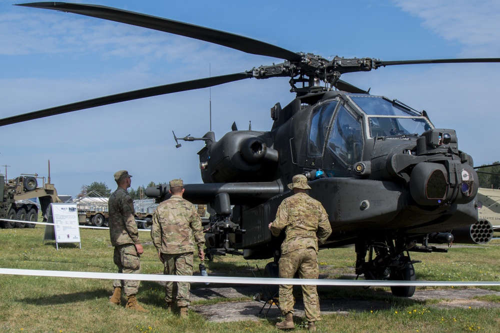 American soldiers assigned to 2CR, 7th ATC stand in front of helicopter discussing the various qualities of its combat efficiency.