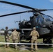 American soldiers assigned to 2CR, 7th ATC stand in front of helicopter discussing the various qualities of its combat efficiency.