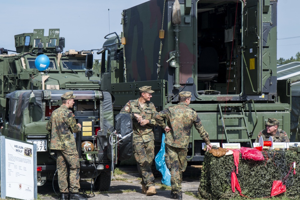 German soldiers stand next to their vehicle as they enjoy the festivities.