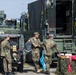 German soldiers stand next to their vehicle as they enjoy the festivities.