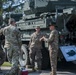 American Soldiers assigned to 2CR, 7th ATC prepare for the festivities as they stand next to their vehicle, the Infantry Carrier Dragoon.