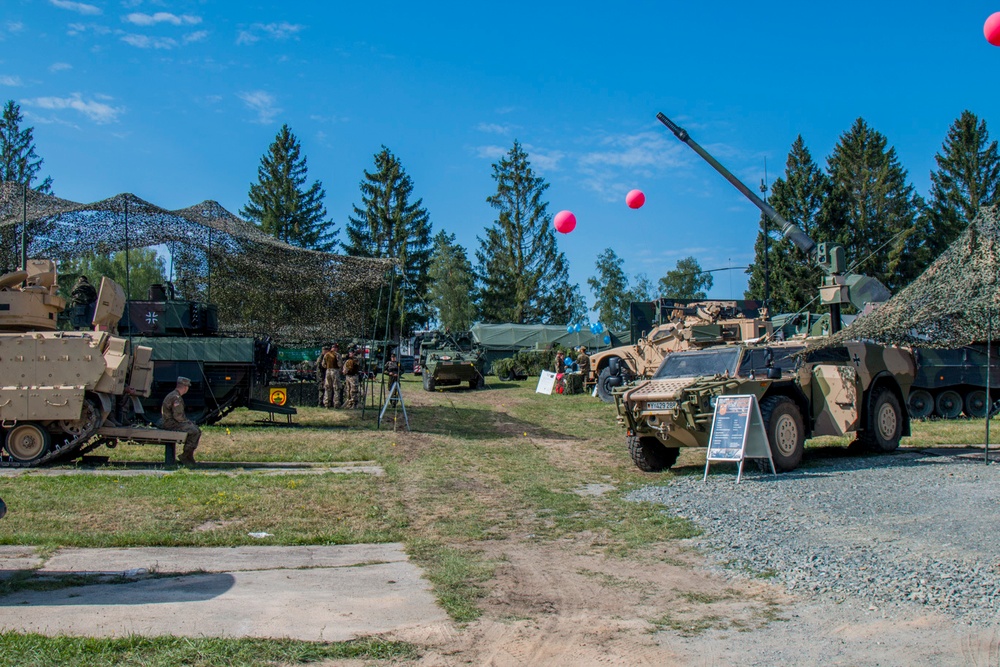 German and American Soldiers stand next to their vehicles enjoying the festivities.