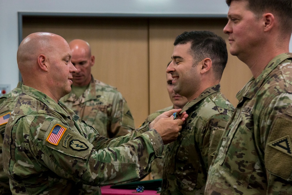 Col. Timothy Davis, 7th Army Training Command’s G3 pins the Army Achievement Medal (AAM) on  Maj. Erik Hamilton, the Exercise Control Center (EXCON) Battle Captain for the summer series of exercises