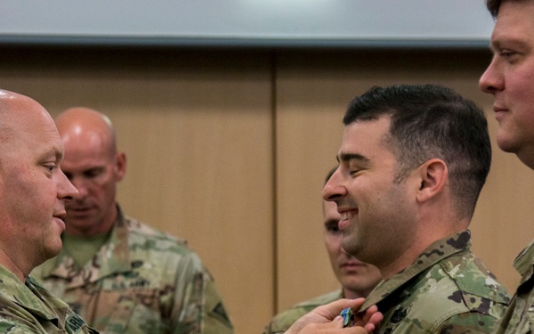 Col. Timothy Davis, 7th Army Training Command’s G3 pins the Army Achievement Medal (AAM) on  Maj. Erik Hamilton, the Exercise Control Center (EXCON) Battle Captain for the summer series of exercises