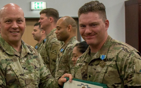 Col. Timothy Davis, 7th Army Training Command (ATC) G3  presents the Army Achievement medal (AAM) to  Spc. Christopher Addy, 7th ATC Communication Specialist