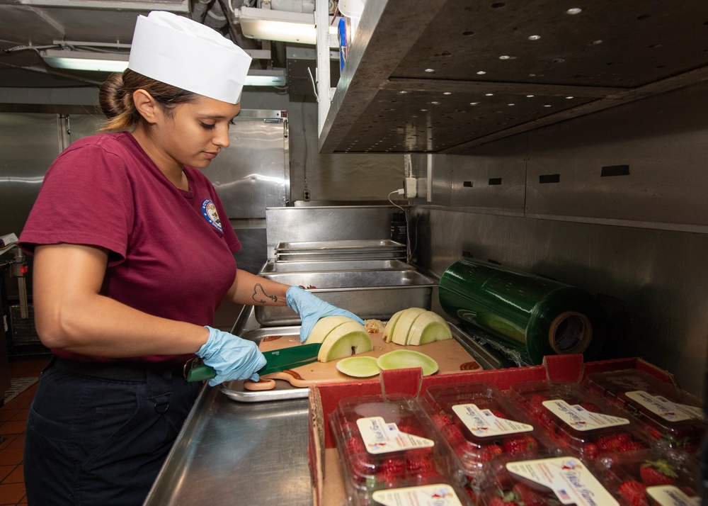 U.S. Sailor prepares food in the galley