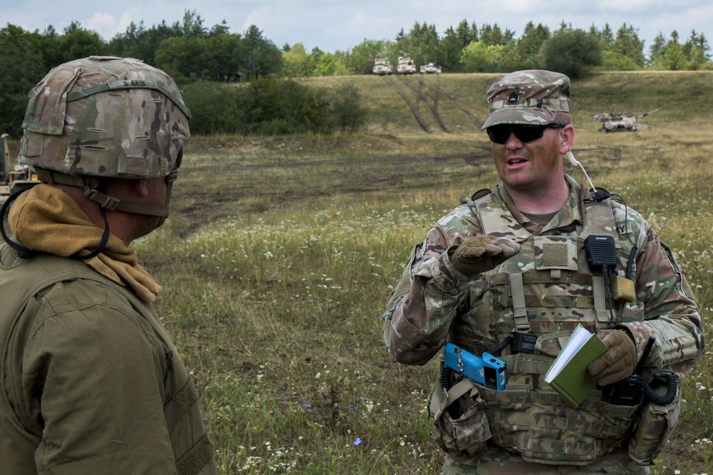 Sfc. Timothy Paddock, an Observer Controller Trainer (OCT) assigned to the Joint Multinational Readiness Center (JMRC) conducts an After Action Review (AAR) with the 1st Brigade 1st Infantry Division (ID)